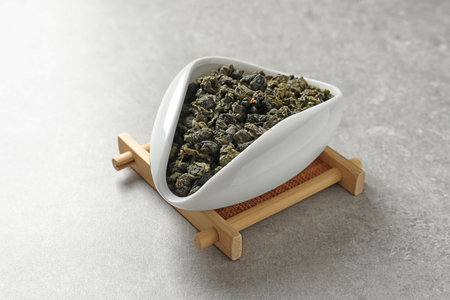 Chahe of Tie Guan Yin oolong tea leaves on gray background