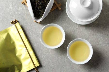 Flat lay composition with cups of Tie Guan Yin oolong tea on gray backgroundの写真素材