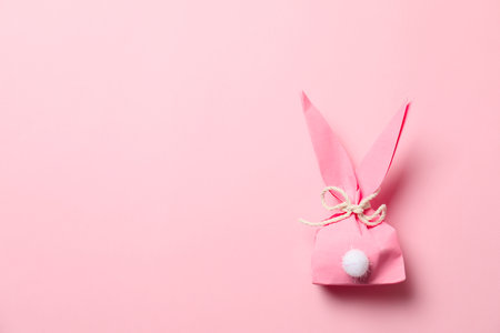 Creative Easter bunny gift bag on color background, top view with space for textの写真素材