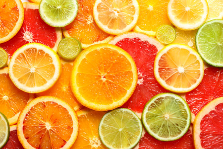 Slices of fresh citrus fruits as background, top viewの写真素材