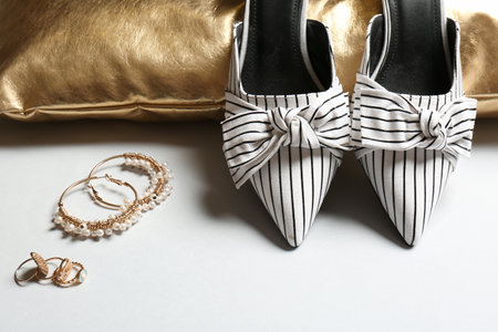 Pillow, lady's shoes and jewelry on light background, closeupの写真素材