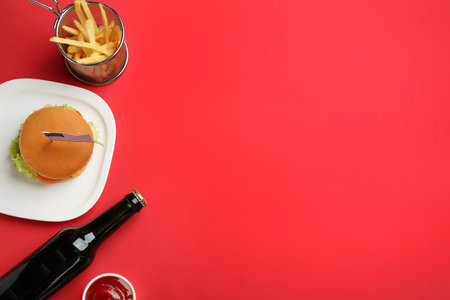 Flat lay composition with burger, French fries and space for text on color background. traditional american foodの写真素材