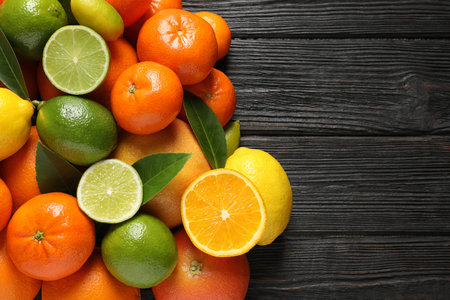 Different citrus fruits with leaves on wooden background, top view. Space for textの写真素材