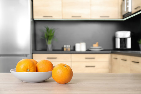 Fresh oranges on wooden table in the kitchen. Space for textの写真素材