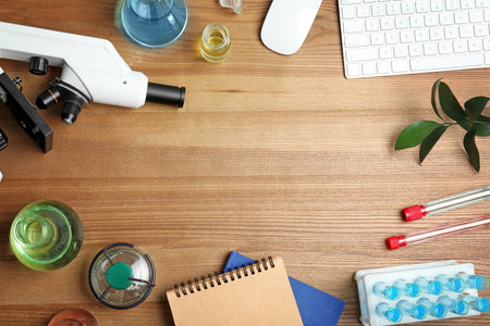 Flat lay composition with laboratory glassware, microscope and space for text on wooden background. Chemistry conceptの写真素材