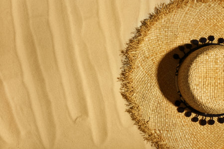 Straw hat on beach sand, top view. Space for textの写真素材