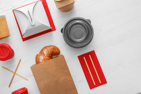 Flat lay composition with paper bag and different takeaway items on wooden background. space for designの写真素材