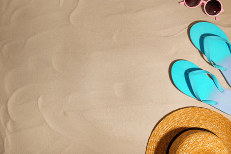 Beach accessories on sand, top view. Space for textの写真素材