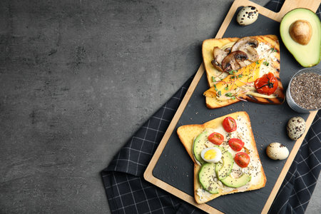 Different toasts with avocado, mushrooms, cherry tomatoes and chia seeds served on gray table, top view. Space for textの写真素材