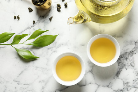 Flat lay composition with cups of Tie Guan Yin oolong tea on marble backgroundの写真素材