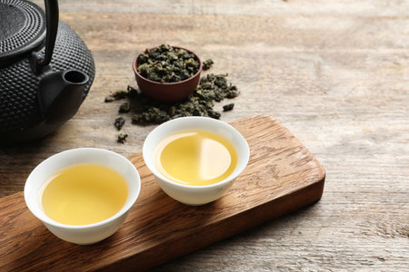 Cups and teapot of Tie Guan Yin oolong on wooden table. Space for textの写真素材