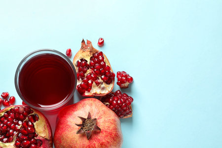 Glass of pomegranate juice and fresh fruits on color background, top view with space for textの写真素材