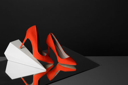 Pair of lady's shoes on table against black background, space for textの写真素材