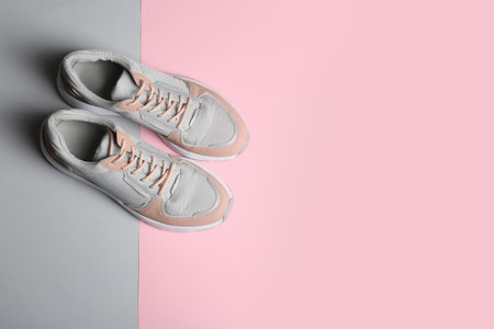 Pair of sports shoes on color background, top view. Space for textの写真素材
