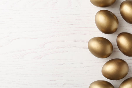Many golden eggs and space for text on wooden background, top viewの写真素材