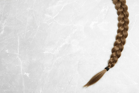 Braided hair on gray background, top view with space for textの写真素材