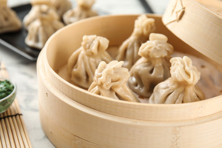 Bamboo steamer with tasty baozi dumplings on table, closeupの写真素材