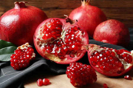 Ripe pomegranates on wooden board, closeup. Tasty fruitsの写真素材