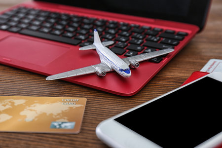 Composition with airplane model and laptop on wooden table. travel agency conceptの写真素材