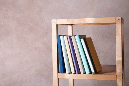 Different books on shelf against color background. Space for textの写真素材