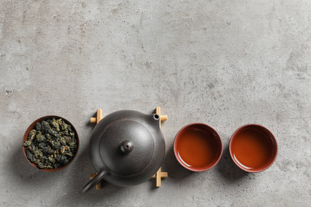 Flat lay composition with cups of Tie Guan Yin oolong tea and space for text on gray backgroundの写真素材