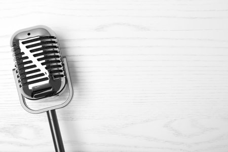 Retro microphone on wooden background, top view with space for textの写真素材