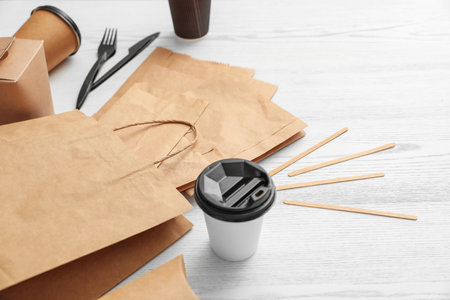Paper bags and different takeaway items on wooden background. space for designの写真素材