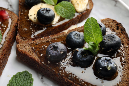 Tasty toast with blueberries, honey and chia seeds on plate, closeupの写真素材