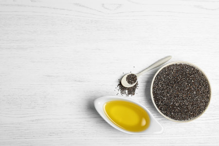 Flat lay composition with chia oil and seeds on wooden background. Space for textの写真素材