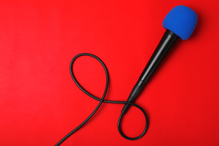 Modern microphone on color background, top view with space for textの写真素材