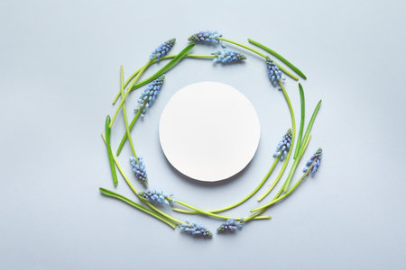 Beautiful spring muscari flowers and card on light background, flat lay. Space for textの写真素材