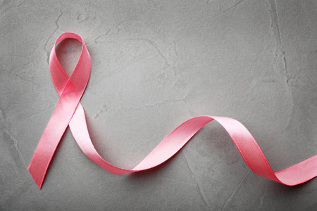 Pink ribbon on gray background, top view with space for text. breast cancer awareness conceptの写真素材