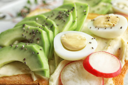 Tasty toast with avocado, quail egg and chia seeds, closeupの写真素材