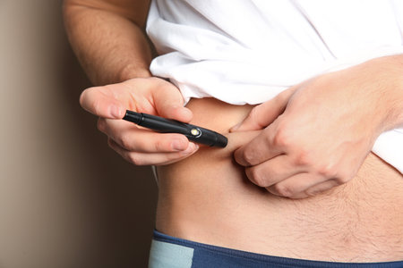 Man doing insulin injection in stomach, closeup. Diabetes disease