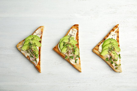 Tasty toasts with avocado, sprouts and chia seeds on white wooden background, top viewの写真素材
