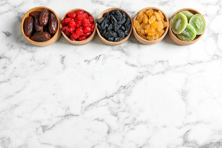 Bowls of different dried fruits on marble background, top view with space for text. healthy lifestyleの写真素材