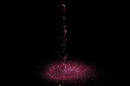 Sprinkling rose glitter on black background, bokeh effectの写真素材