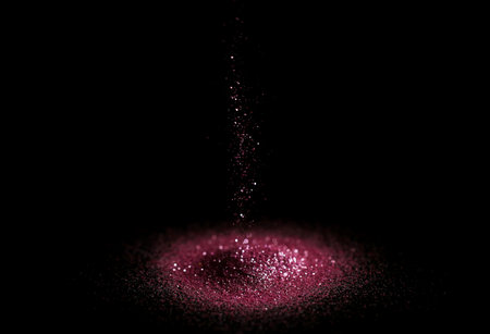 Sprinkling rose glitter on black background, bokeh effectの写真素材