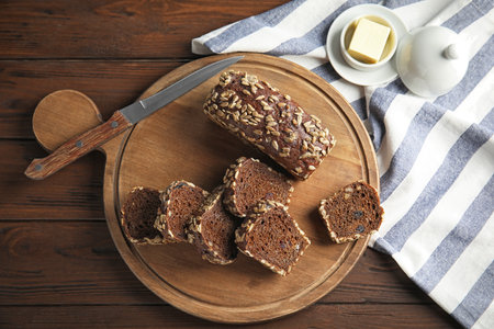 Tasty rye bread served on wooden table, flat lay