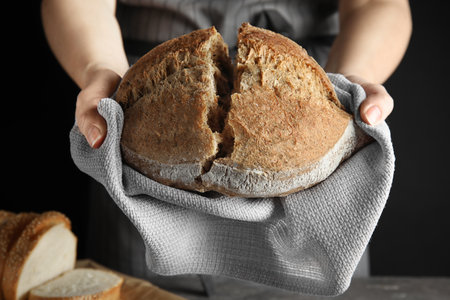 Woman holding tasty bread over table, closeupの写真素材