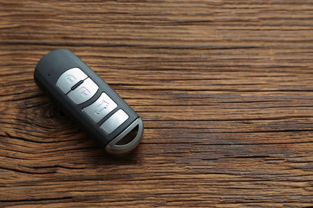Remote car key on wooden background, top view. Space for textの写真素材