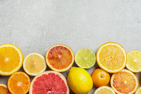 Different citrus fruits on gray background, flat lay. Space for textの写真素材