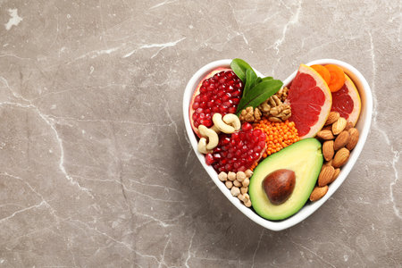 Bowl with heart-healthy diet products on color background, top view. Space for textの写真素材