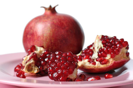 Plate with ripe pomegranates on table against white background, closeupの写真素材