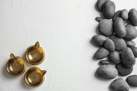 Zen stones and oil lamps on light background, top view with space for textの写真素材