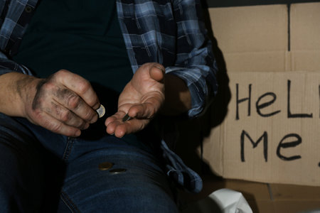 Poor senior man counting coins near cardboard sign HELP ME, closeupの写真素材