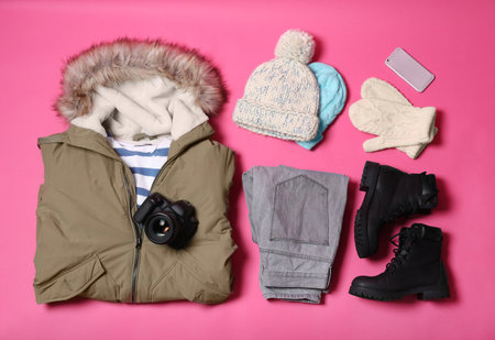 Flat lay composition with warm clothes for winter vacation on color backgroundの写真素材