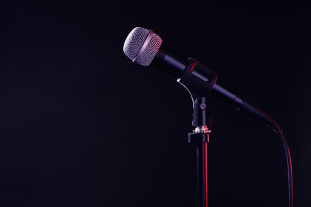 Modern microphone on stand against black background. Space for textの写真素材