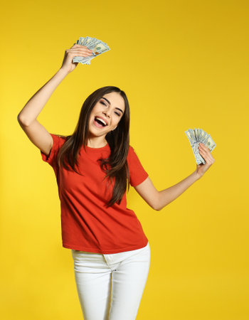 Young woman with money on color backgroundの写真素材