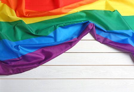 Bright rainbow gay flag on wooden background, top view with space for text. LGBT communityの写真素材